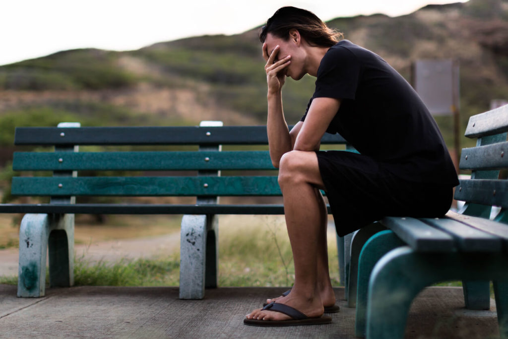 young-man-sitting-down-depressed-with-his-hands-over-face